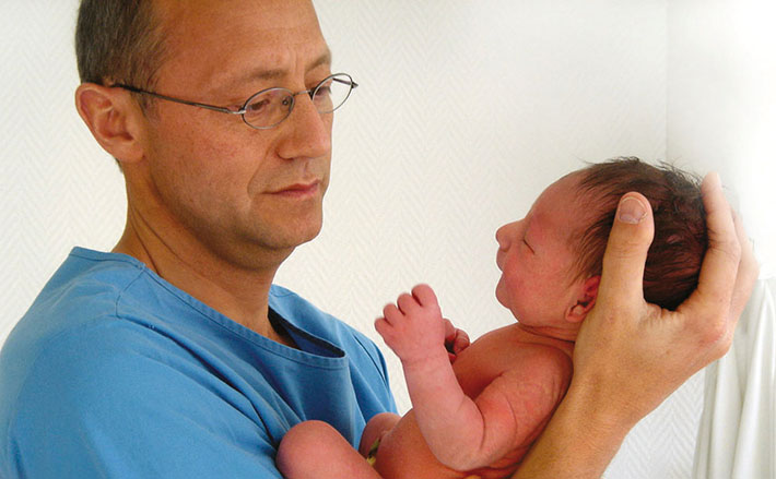 Chefarzt Dr. Müller mit einem Neugeborenen