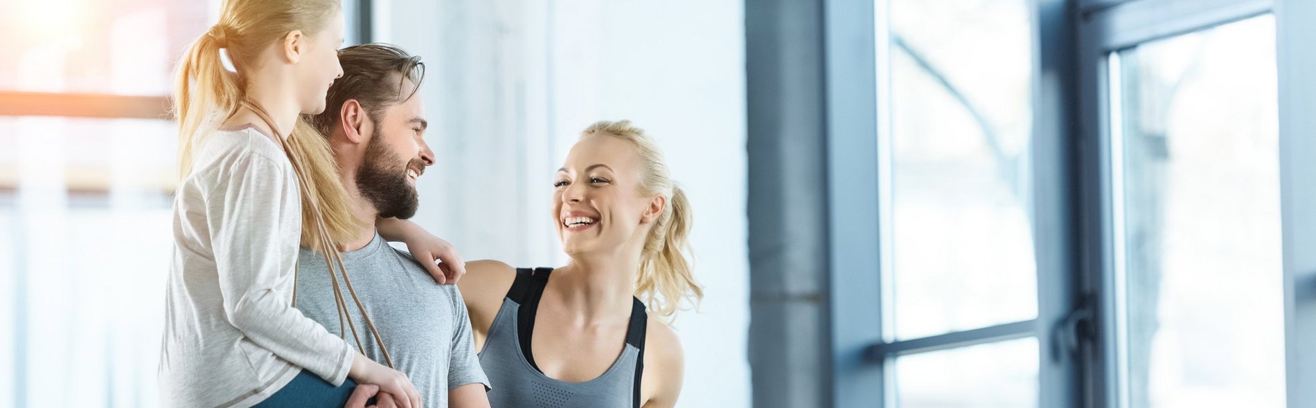 Foto einer glücklichen Familie, die im Fitnesscenter zusammensteht.