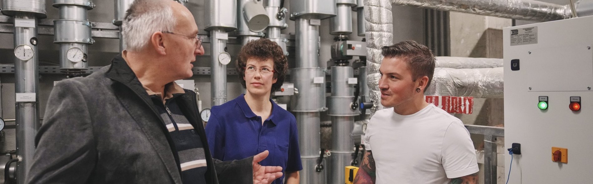 Energieaudit Das Foto zeigt eine Besprechung von Ingenieuren im Heizungskeller.